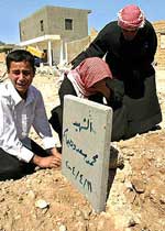 Boy and 2 women crying at a graveside in Fallujah after the US lead attack in november 2004.