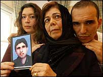 Omar Deghaye's Mother, holding a photo of her son, with his sister & brother in their home in Saltdean.